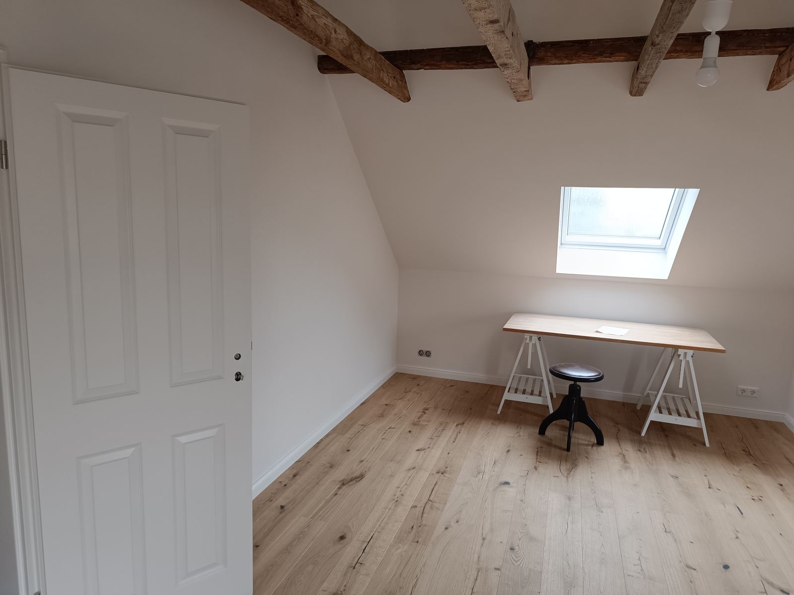 Ausgebautes Dachgeschoss mit Schreibtisch und Dachfenster