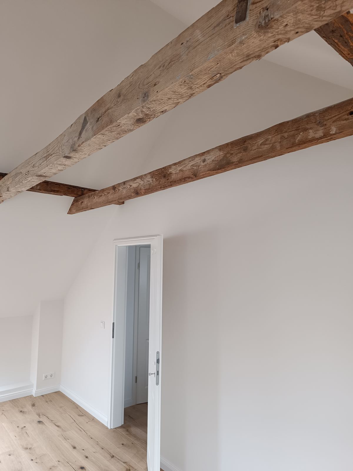Dachgeschoss mit sichtbaren Balken und Türblick