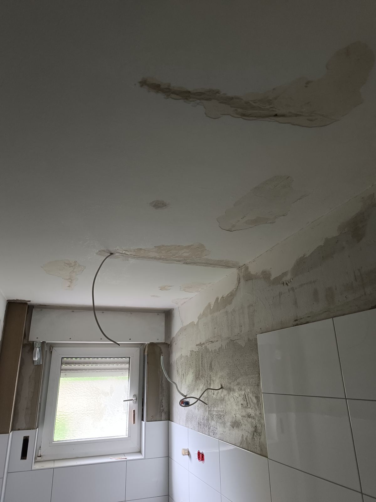 Badezimmerdecke mit Feuchtigkeitsschäden vor der Sanierung