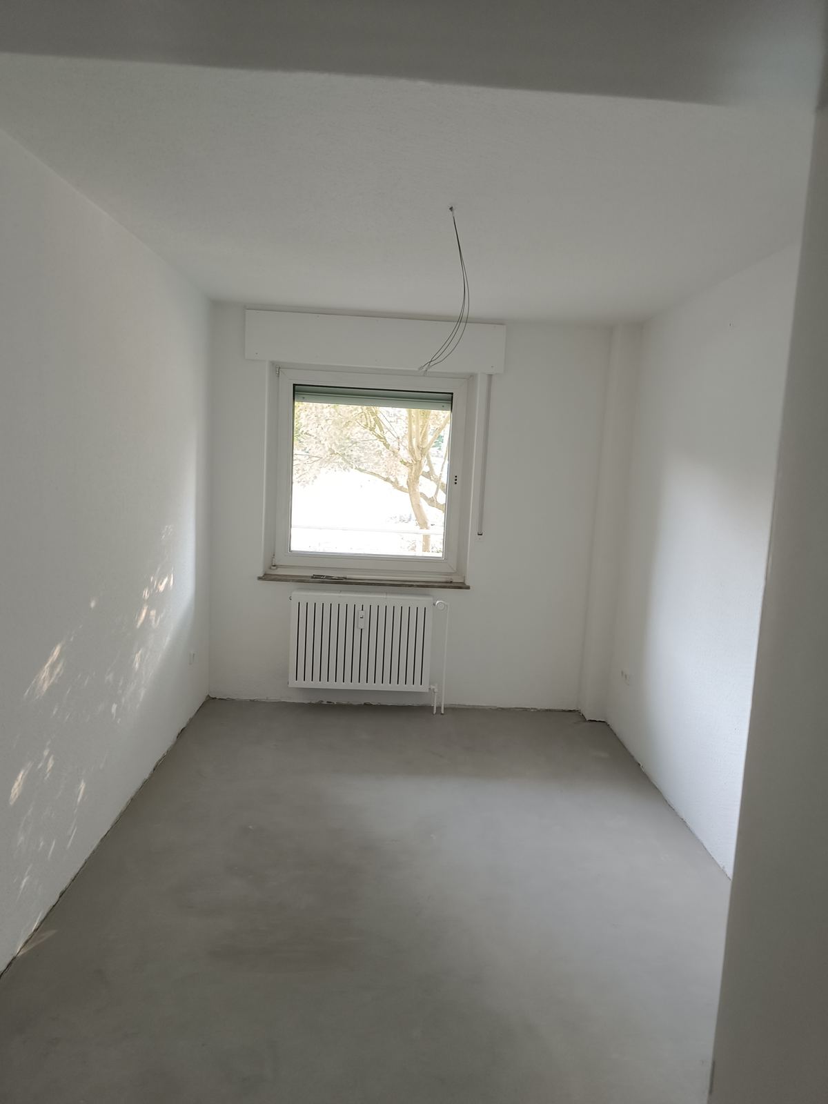 Renovierter Raum mit Fenster und Heizkörper
